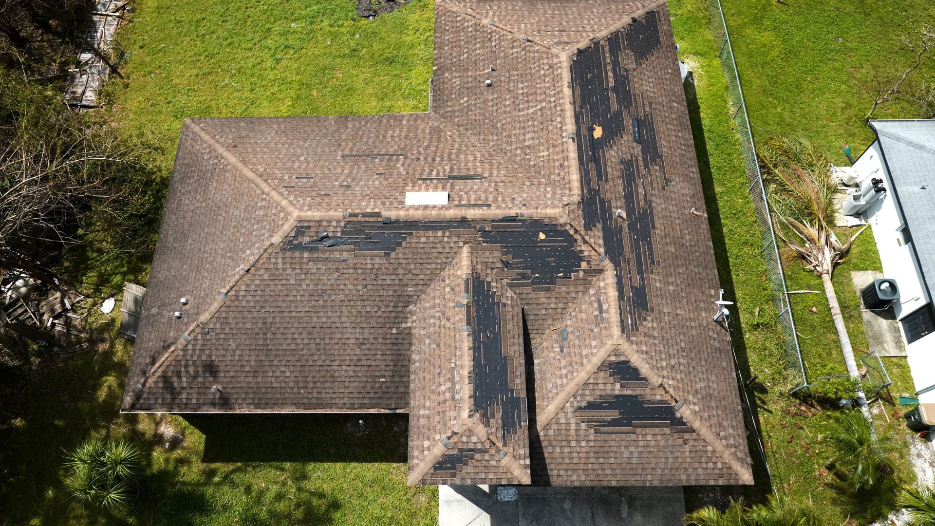 Top-down view of an asphalt roof with hail-stripped granules
