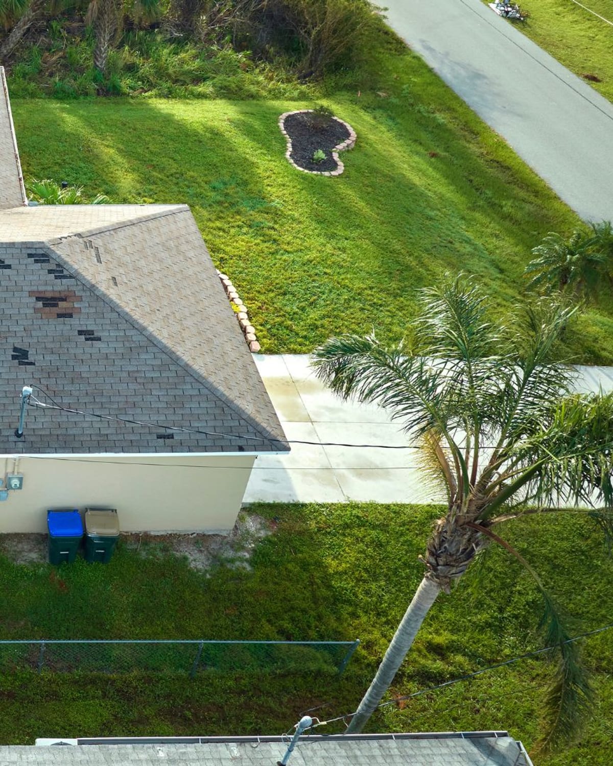 Angled aerial view of a residential roof showing scattered impact damage