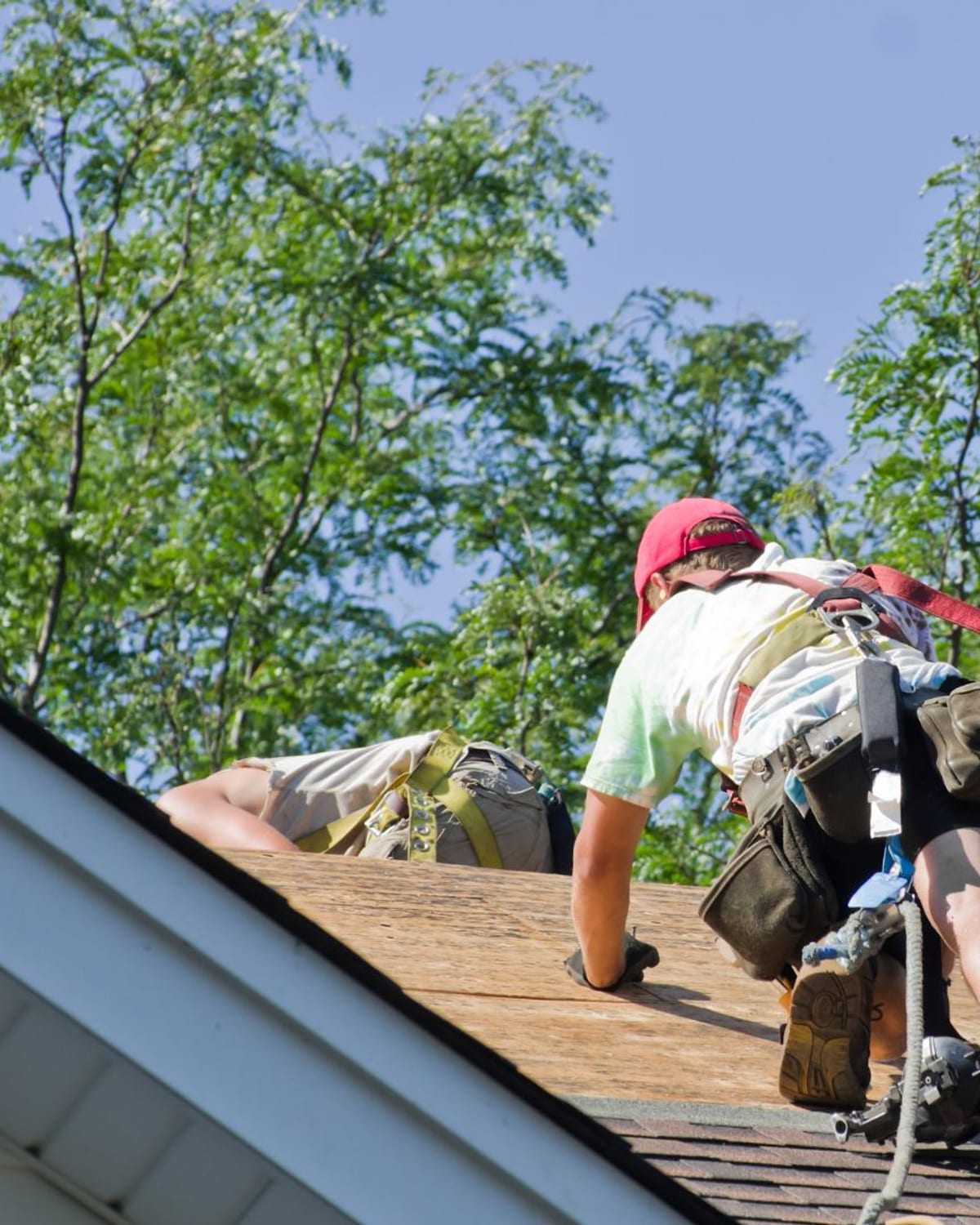 Roofer working up a shingle slope on a Socastee, SC home
