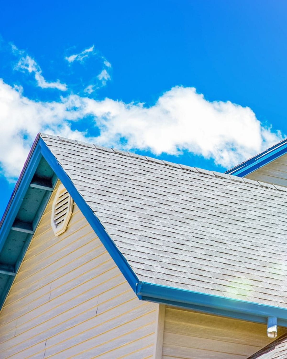 Shingle gables and chimneys on a Shallotte, NC home under a bright sky